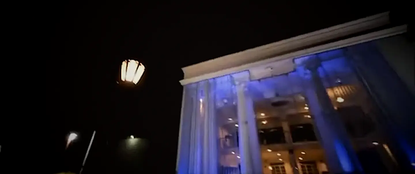 OSMO's colonial facade lit blue at night