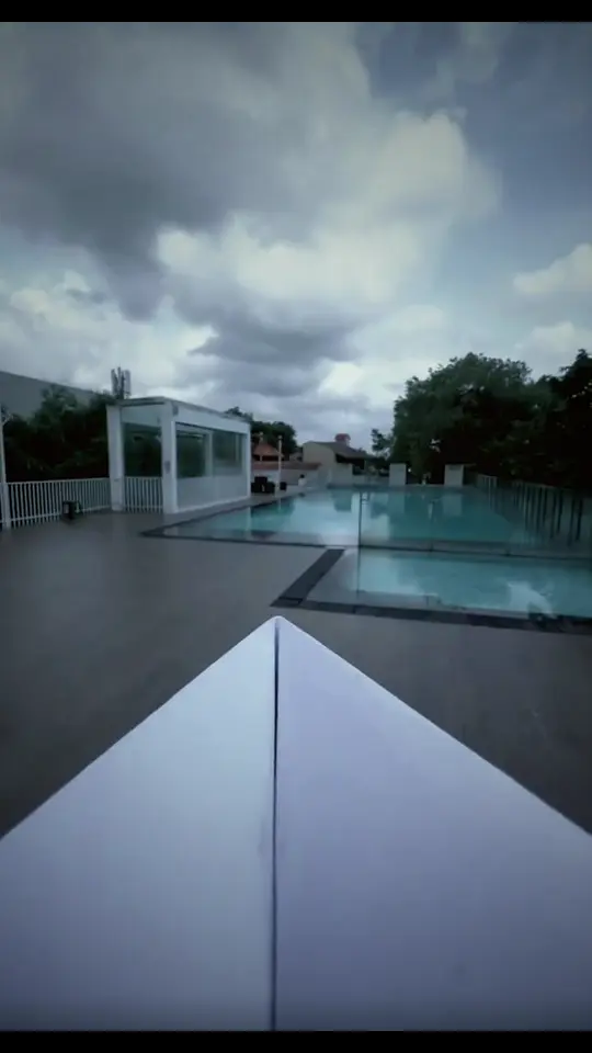 A paper plane's view flying over the OSMO pool toward the colonial entrance